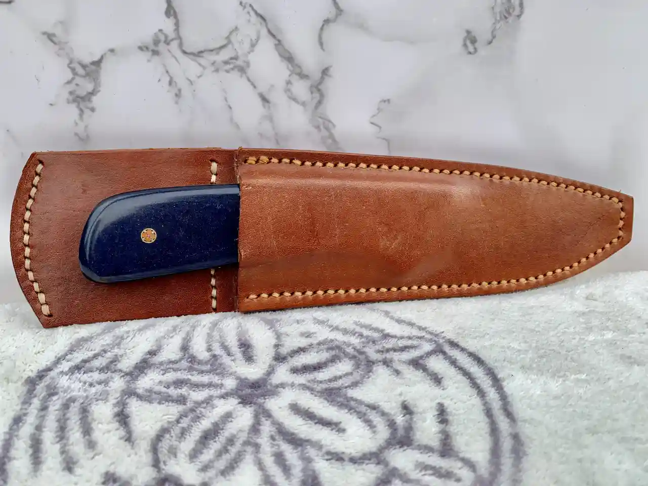 Stainless steel slim skinner with canyon blue Richlite handles in leather sheath