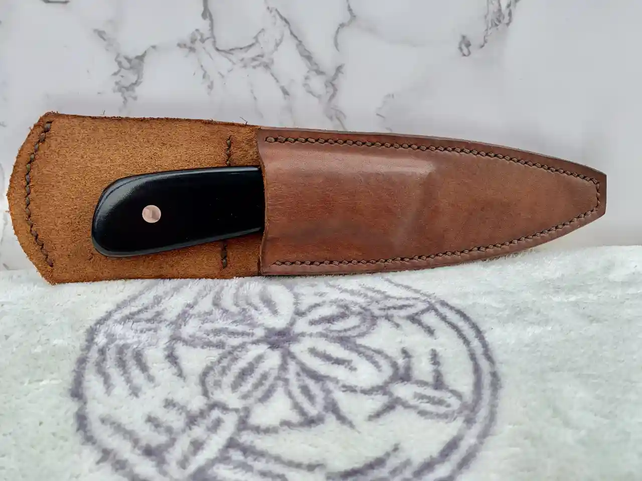 1084 carbon steel slim hunter with black canvas micarta handles in leather sheath