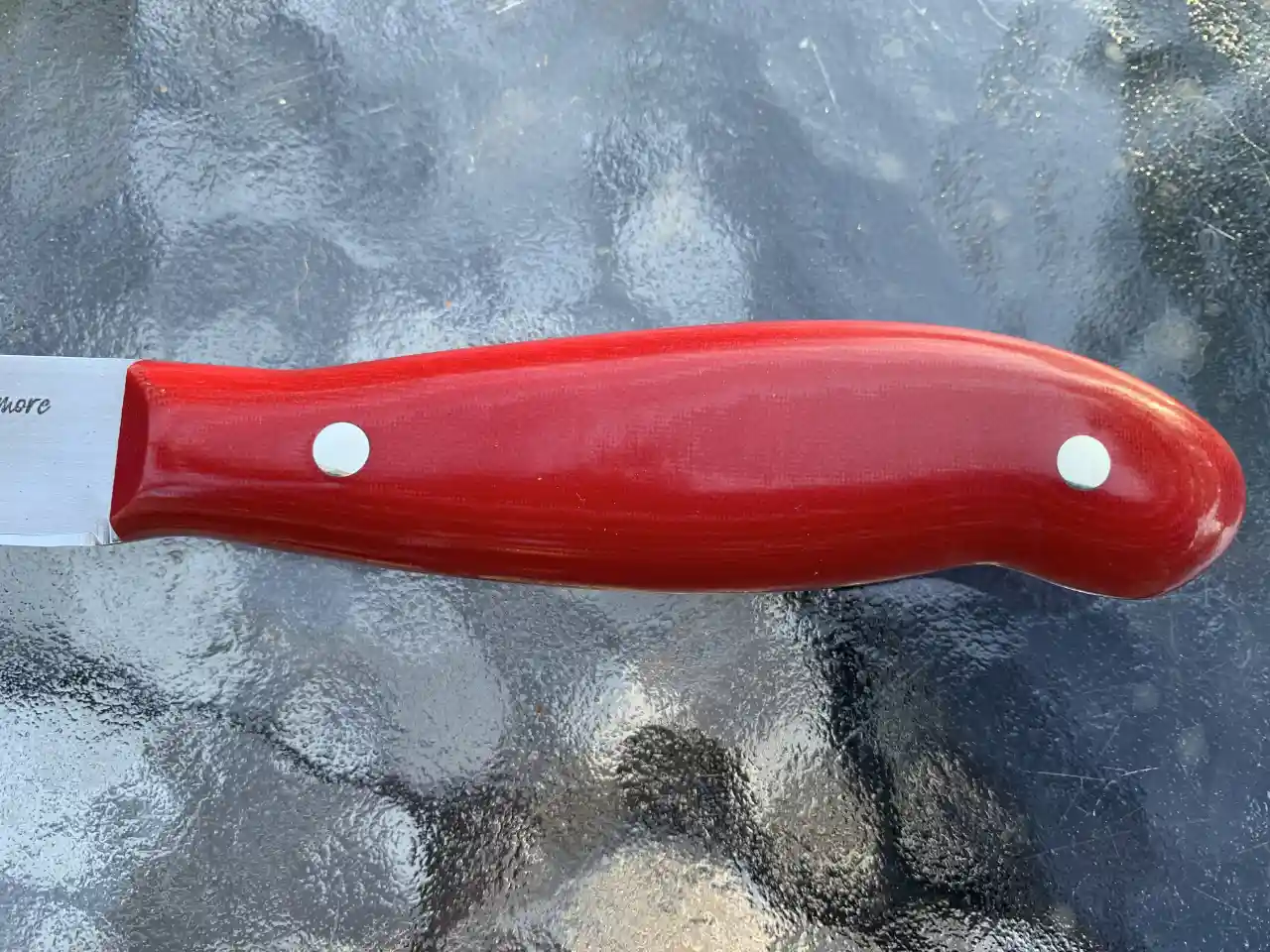 Kitchen paring knife with ruby red micarta handles - closeup of handle front view