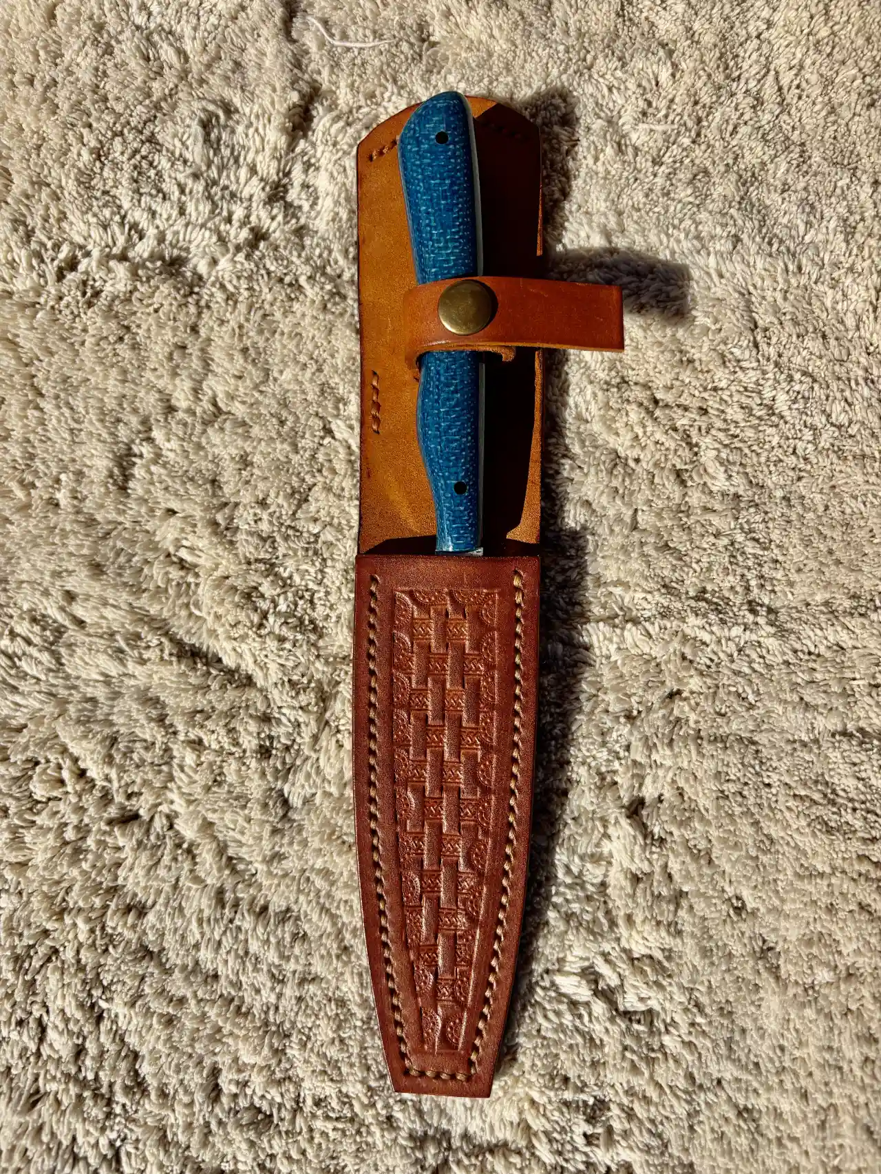 Bird and trout knife with admiral blue jute micarta handles in a custom, hand tooled, leather sheath