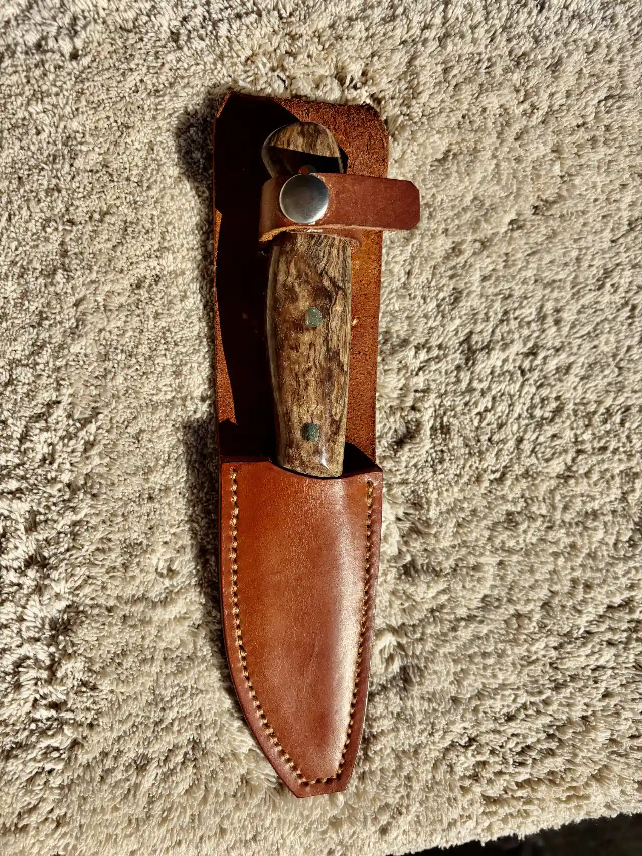 Bushcraft knife with curly mango wood handles in a custom leather sheath